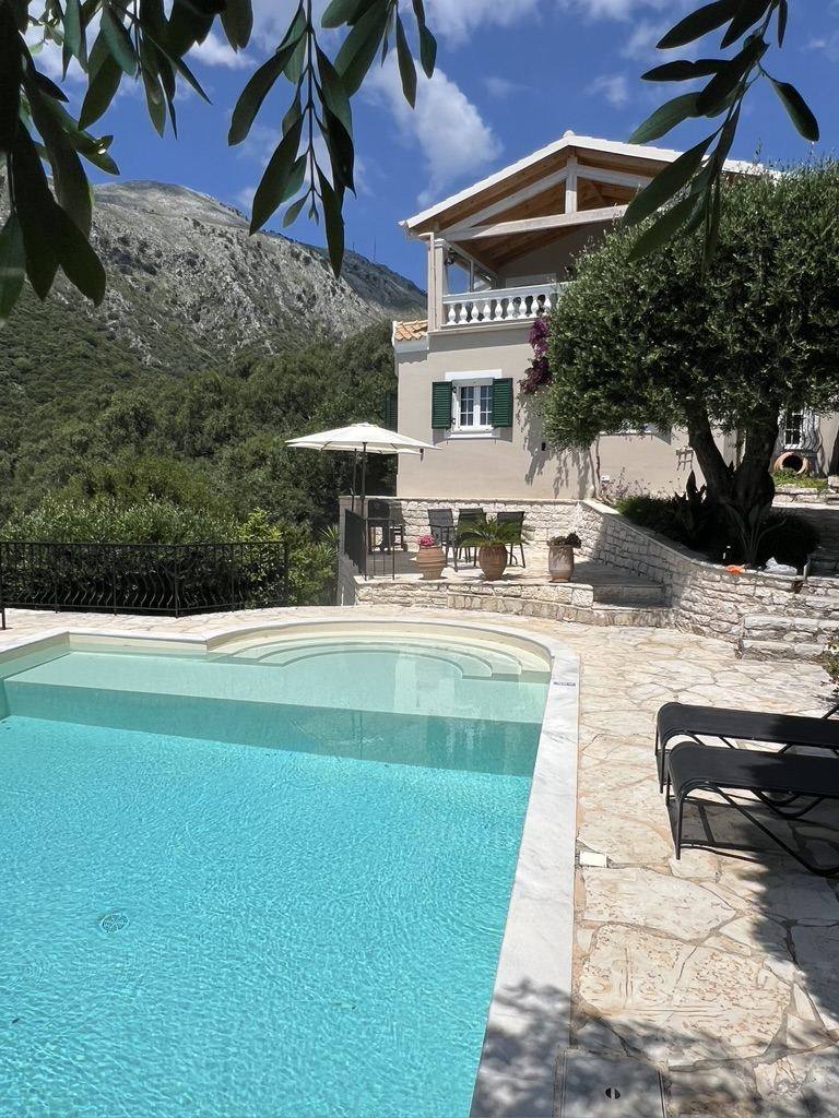 The villa facade seen across the pool