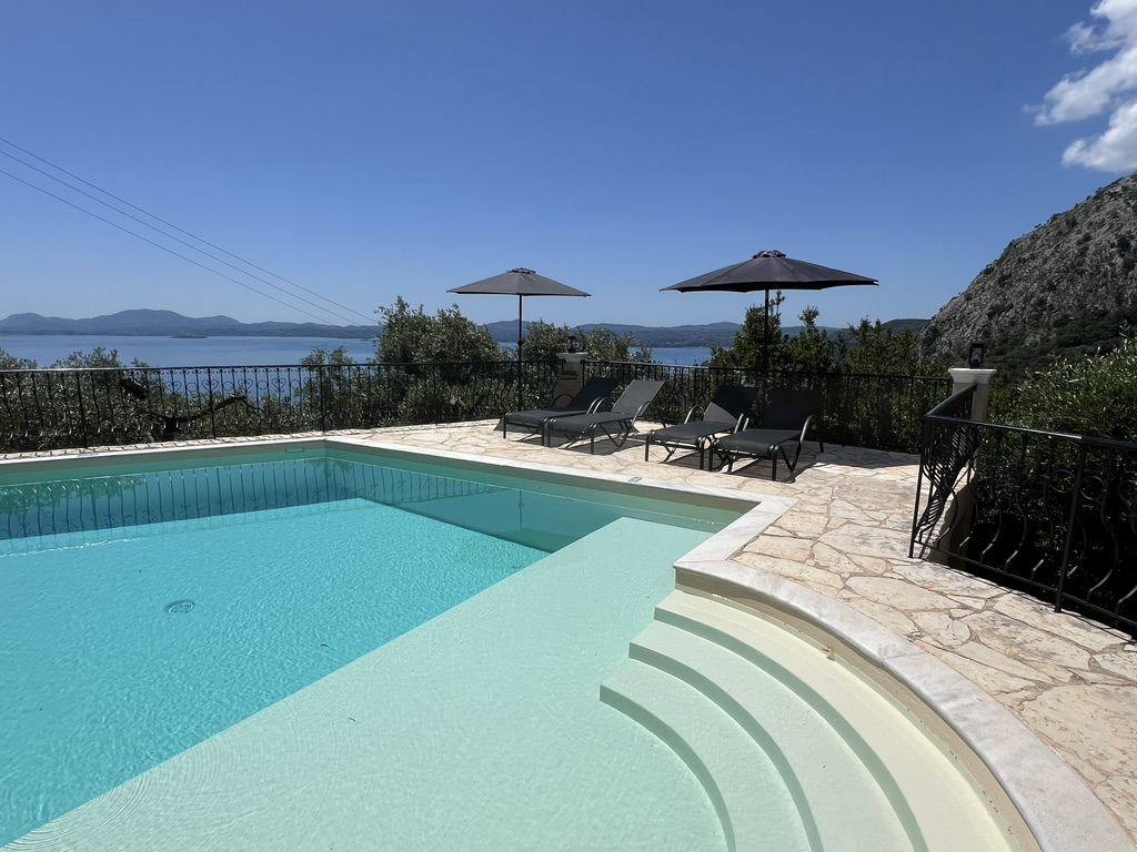 Pool steps and sun loungers facing the sea