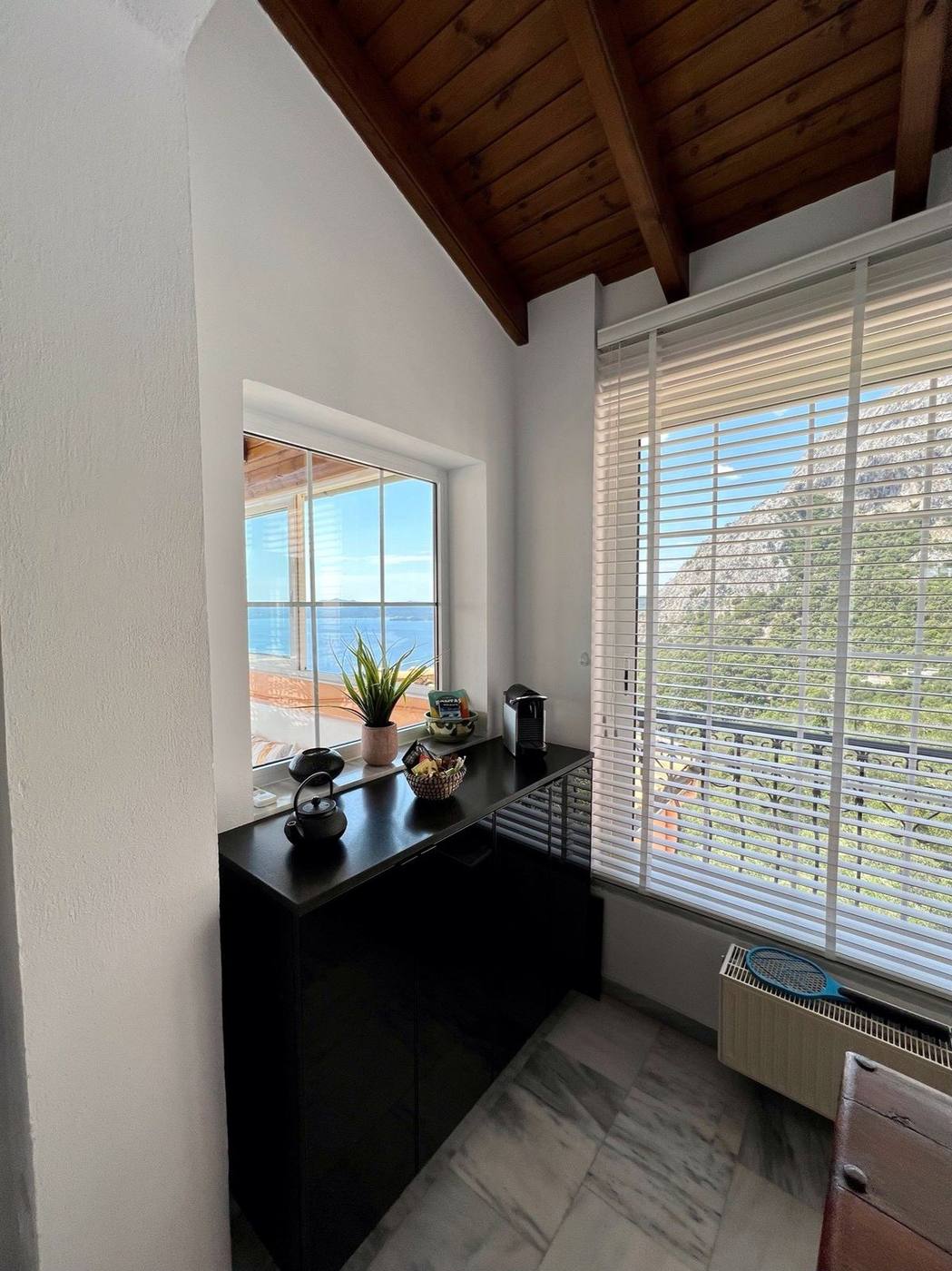 A bright window nook with a glimpse of the sea