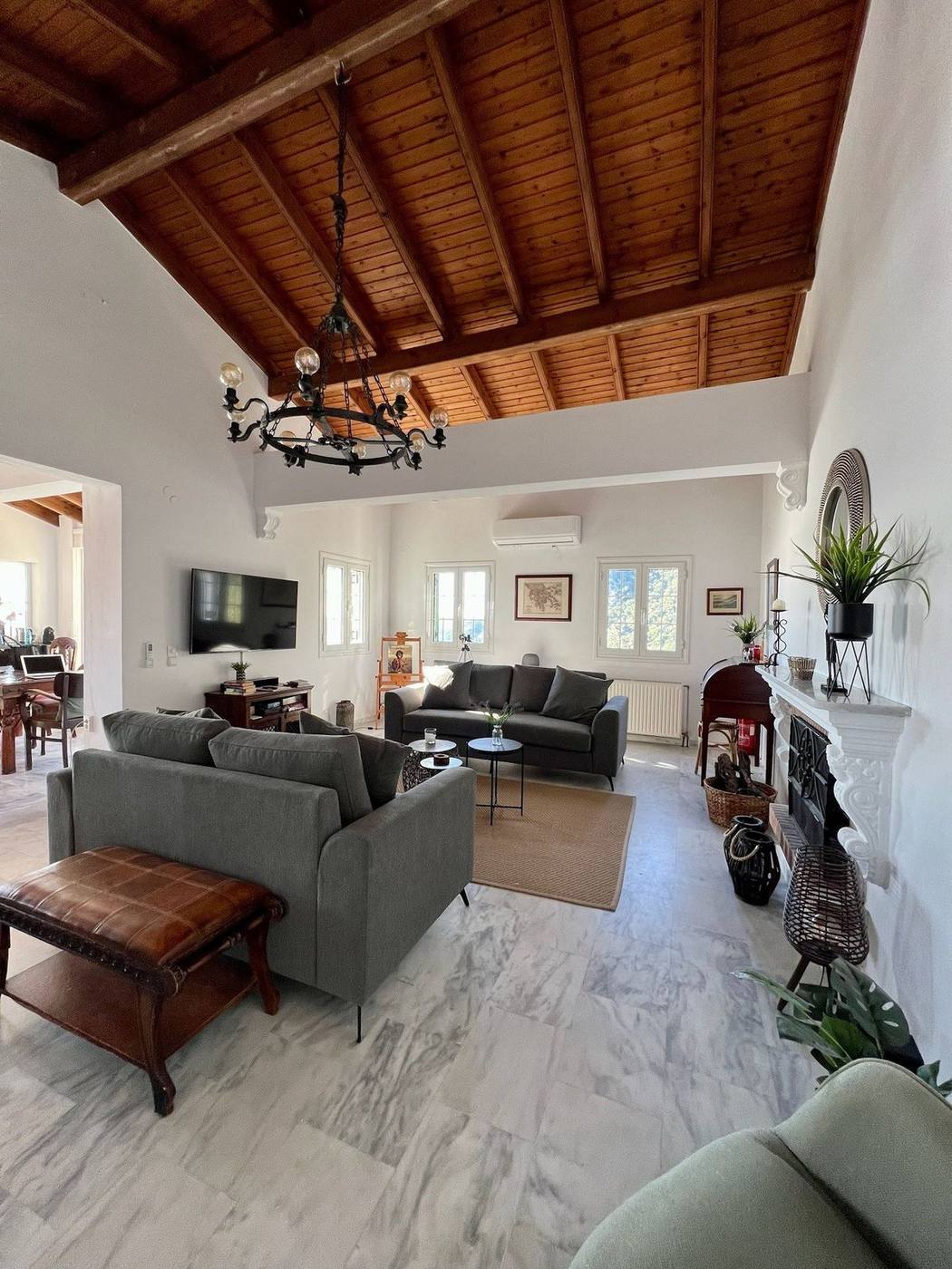 Living room with a high beamed ceiling, sofas and the fireplace