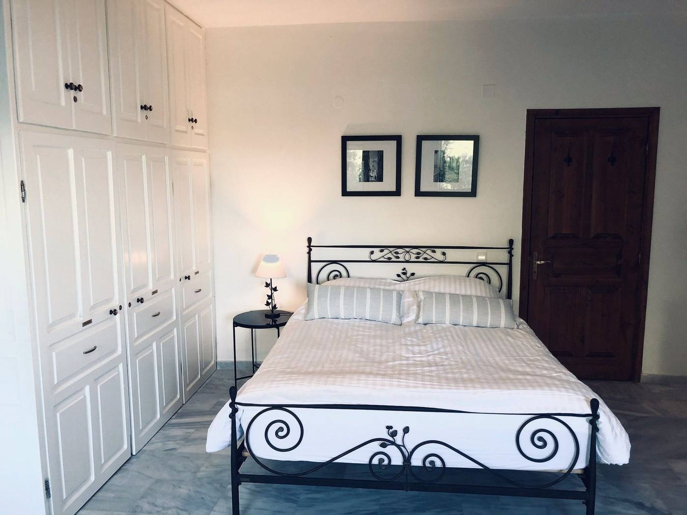 Double bedroom with a wrought-iron bed and fitted wardrobes