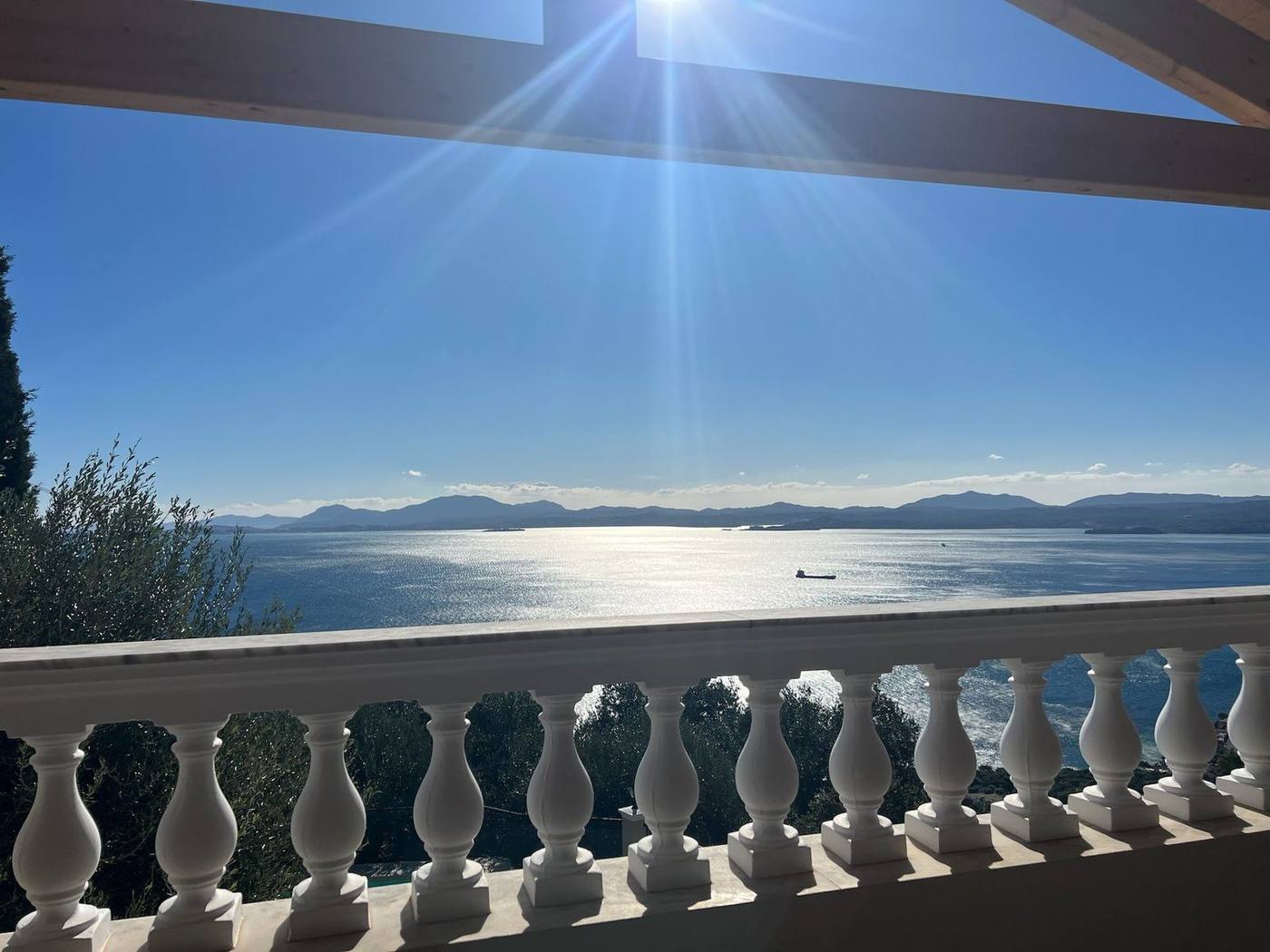 Morning sun over the sea, seen through the balustrade of the covered balcony