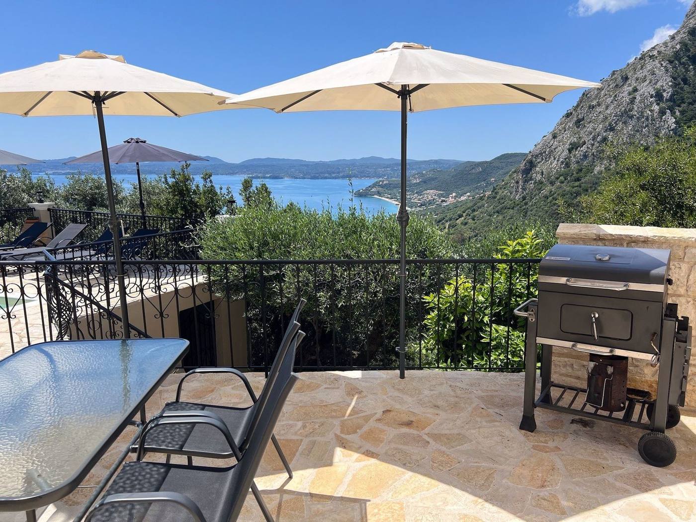 Terrace with the BBQ and umbrellas overlooking the bay