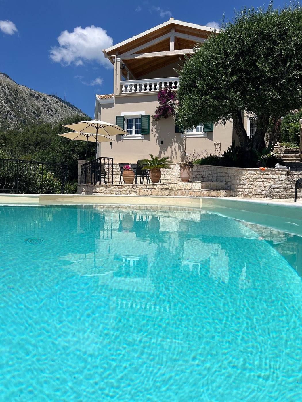 The villa rising behind the pool