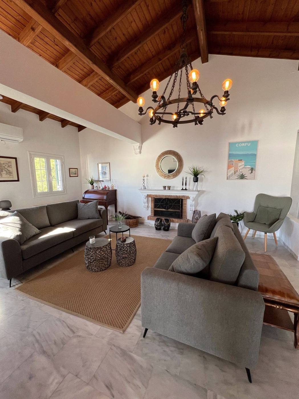 Sitting area by the fireplace under a wrought-iron chandelier