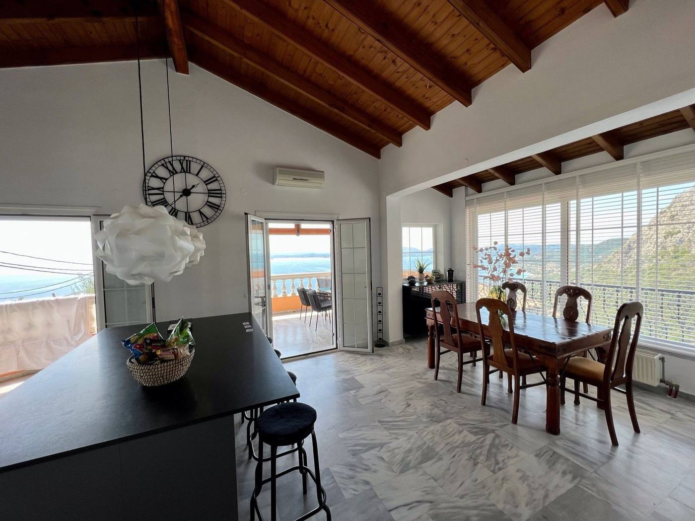 Dining table beside the balcony door with views out to sea