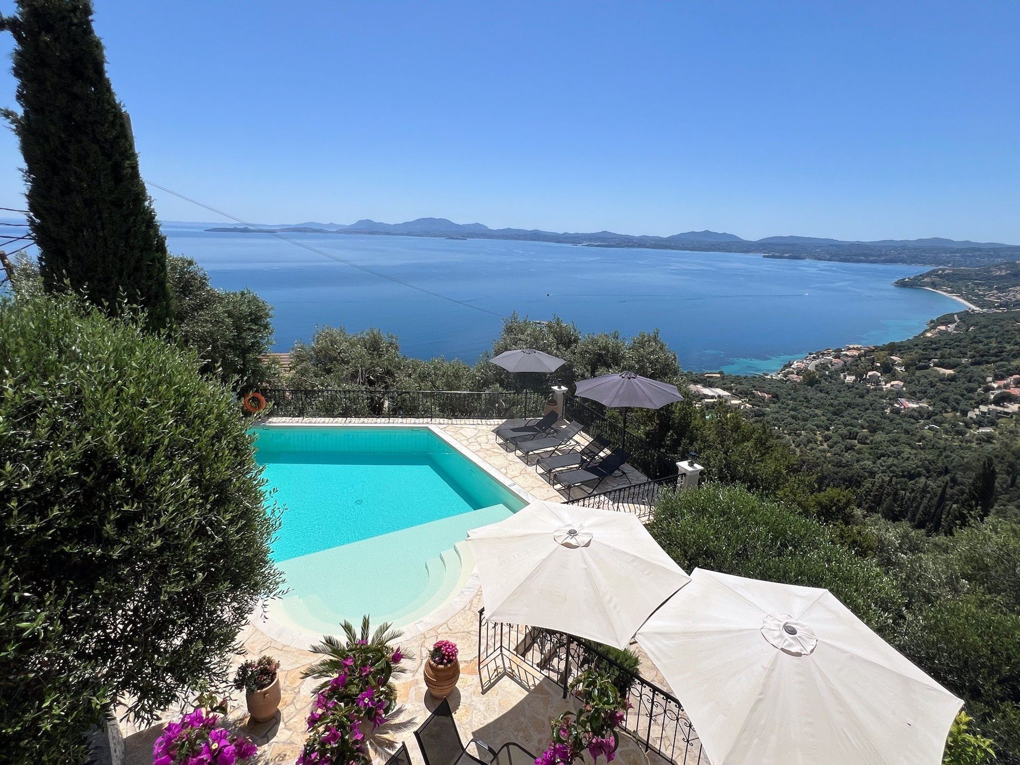 The villa’s turquoise pool with bougainvillea, looking out over the whole bay of Corfu