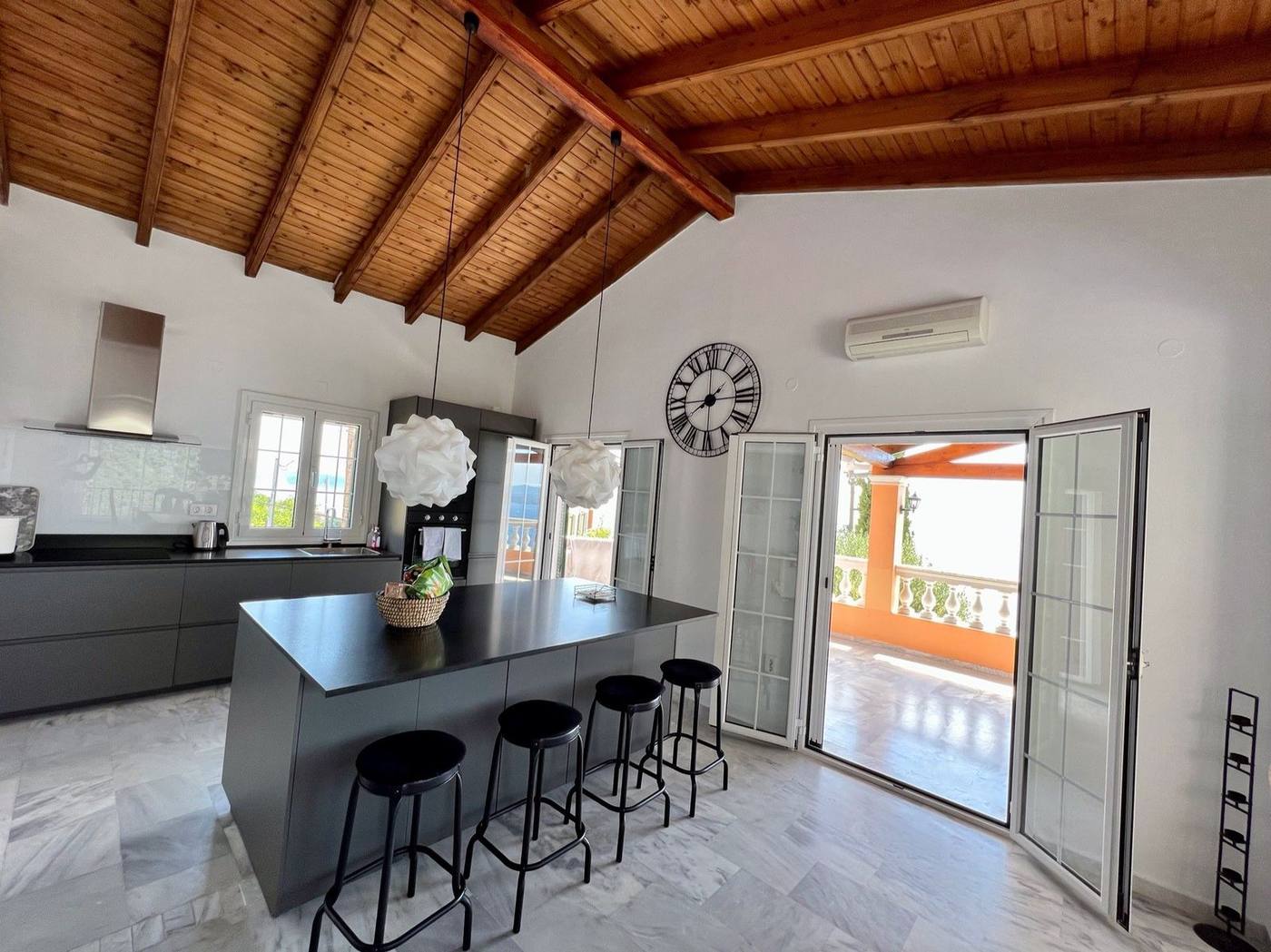 Open kitchen with an island, doors open to the balcony