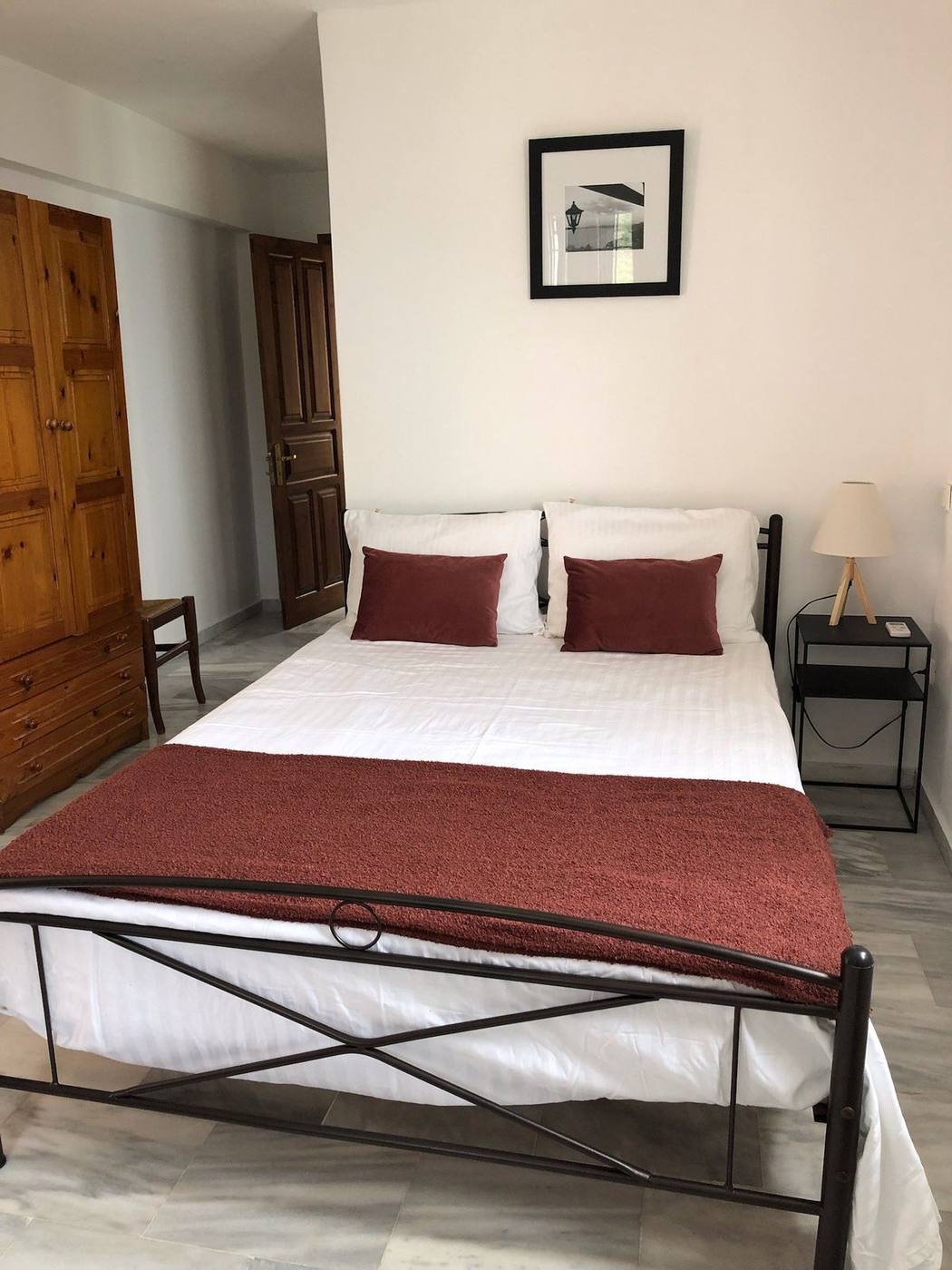 Double bedroom with red cushions and a bedside lamp